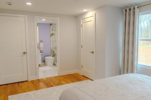 a white bedroom with a bed and a bathroom at The Great Escape in Clintondale