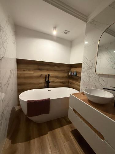 a bathroom with a white tub and a sink at Katerina - Mona Luxury Apartments in Lębork