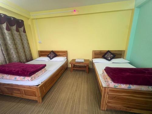two beds in a room at Fun Viewpoint Homestay Darjeeling in Darjeeling