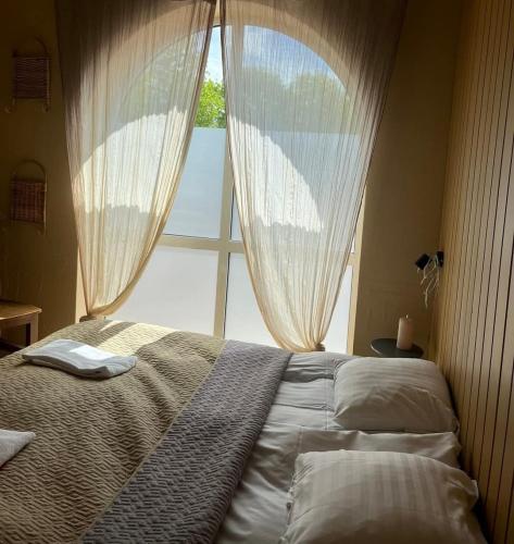 a bedroom with a bed with a large window at Kroghuset - Det Lille Hotel in Tarm