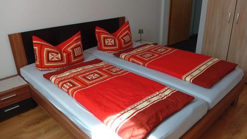two beds with red and white blankets and pillows at Ferienwohnung Wolfi in Gotha
