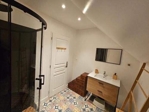 a bathroom with a shower and a sink and a mirror at Home Gãyatri in Angé