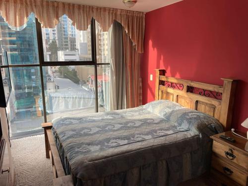 a bedroom with a bed and a large window at Muy cerca, a pasos de la Embajada de EEUU in La Paz
