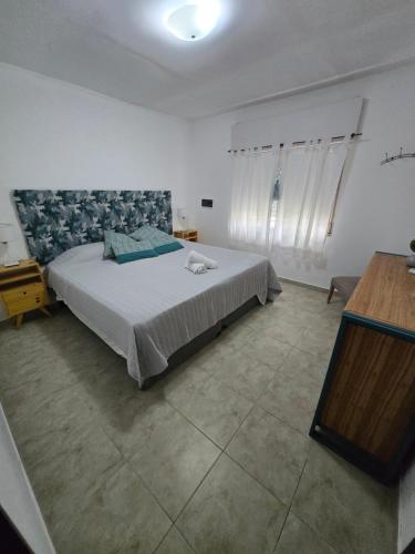 a bedroom with a large bed and a table at Veronica mini home 1 in Verónica