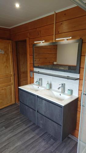 a bathroom with two sinks and a mirror at O'Doubs Chalet in La Chaux Neuve