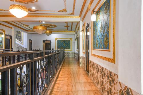 a corridor in a building with paintings on the walls at SPOT ON The Green Palace in Lālbāgh
