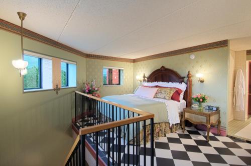 a bedroom with a large bed and a staircase at Woodcliff Hotel and Spa in Fairport