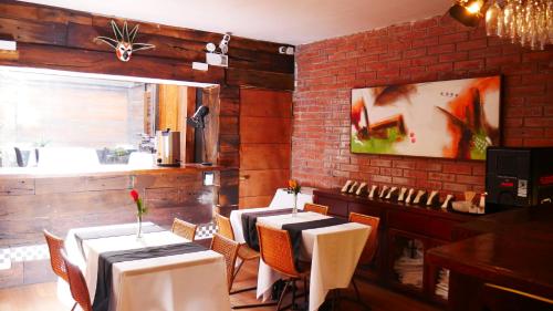 a restaurant with tables and chairs and a brick wall at Hotel Sonetto in Santiago