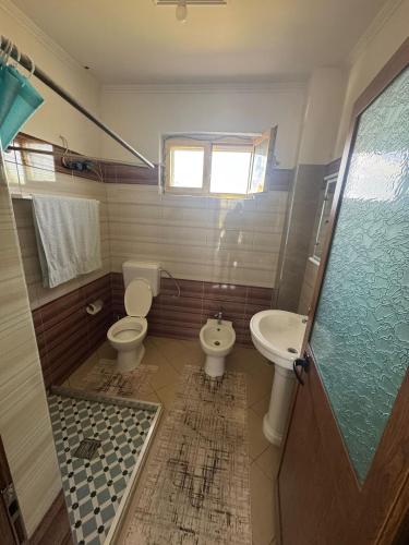 a bathroom with a toilet and a sink at Villa Gjeci Tale in Tale