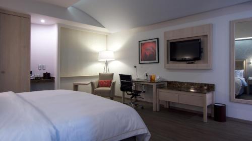 a hotel room with a bed and a desk and a tv at Holiday Inn Express Mexico- Toreo by IHG in Mexico City