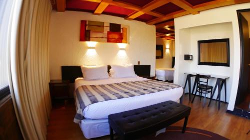 a hotel room with a bed and a table and chairs at Hotel Sonetto in Santiago