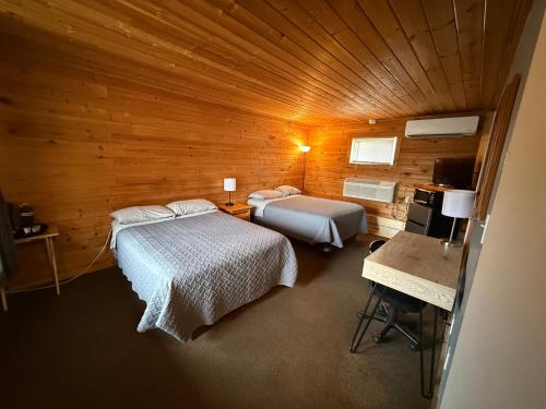 a room with two beds in a wooden cabin at Rustic Inn in Park Rapids