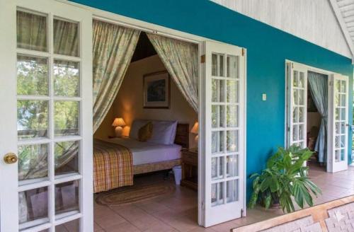 a bedroom with a bed in a room with windows at The Rocks Villa in Tower Isle