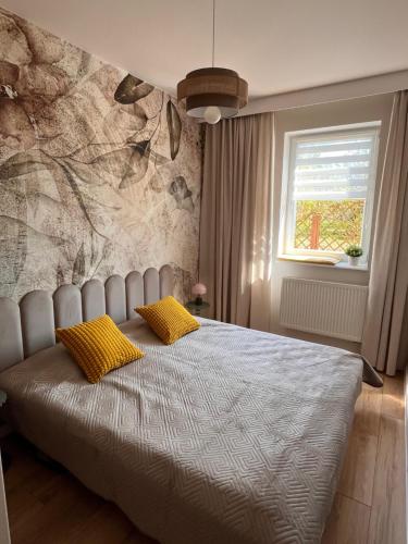 a bedroom with a bed with two yellow pillows at Piastowy Dwór in Jastrzębia Góra