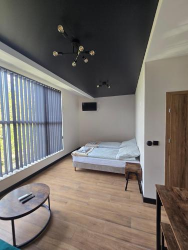 a bedroom with a bed and a table in it at TRIO HoSteL in Hajnówka