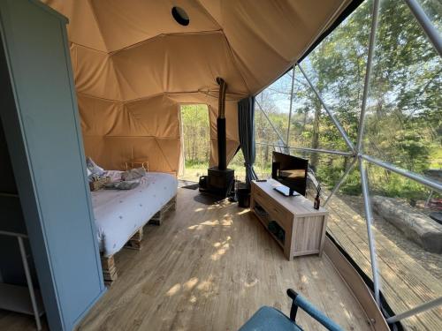 a room with a bed and a tv in a tent at Cherry Tree Dome in Smeeth