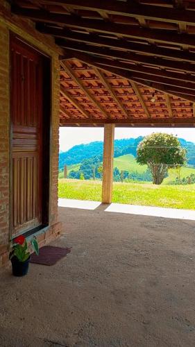 a porch with a view of a tree in the distance at Sitio Vale Verde da Serra in Monte Verde