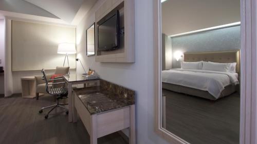 a hotel room with a bed and a desk with a computer at Holiday Inn Express Mexico- Toreo by IHG in Mexico City
