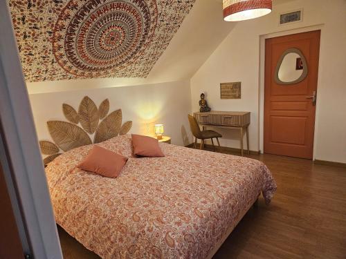 a bedroom with a bed and a table with a desk at Home Gãyatri in Angé