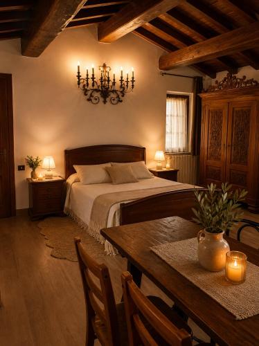 a bedroom with a bed with a table and a chandelier at Il Castelletto di Gomo - Relax nella natura con SPA privata outdoor in Godiasco