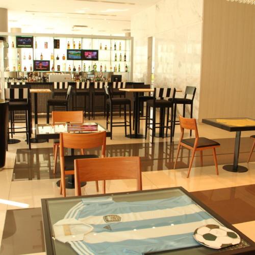 a restaurant with tables and chairs and a bar at Gran Bourbon Hotel Asuncion in Asuncion