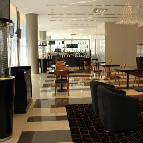 a restaurant with tables and chairs and a bar at Gran Bourbon Hotel Asuncion in Asuncion