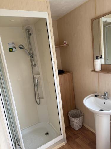 a bathroom with a shower and a sink at Holiday Caravan Orchards Holiday Village in Brightlingsea