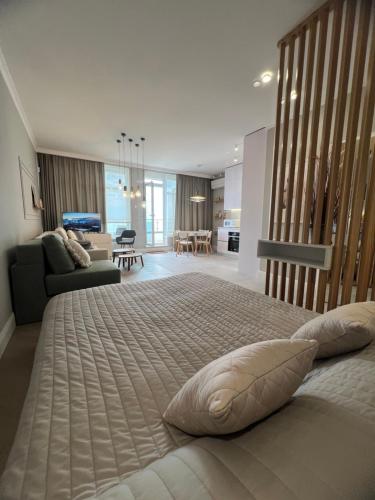 a bedroom with a large bed and a living room at Апартаменты у моря Magnit первая линия in Odesa