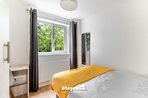 a bedroom with a bed and a window at Spacious 2BR Home w Garden 2-Min Walk to Town in Stockport