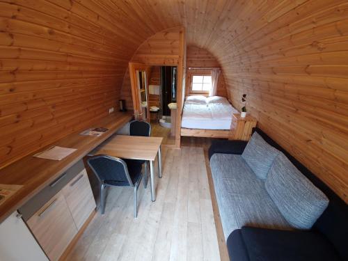 a small room with a bed and a table and chairs at 05 Premium Camping Pod "Gröde" in Silberstedt