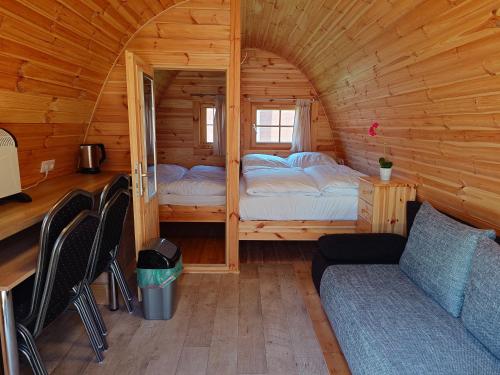 a small room with two beds in a wooden cabin at 43 Camping Pod "Molfsee" in Silberstedt