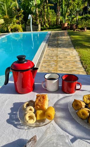 a table with a plate of food and a cup of coffee at Casa na Serra Canto do Jair in Casimiro de Abreu