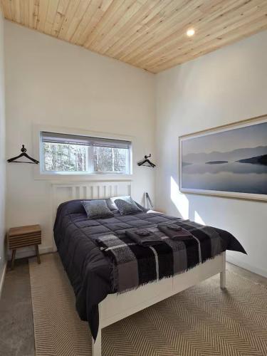 a bedroom with a large bed and a painting on the wall at Hebergement du grenier 2 0 in Notre-Dame-des-Monts