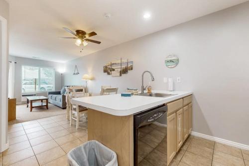 a kitchen with a sink and a living room at Harbor Village Pool Building Condo 104 in Garden City