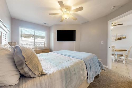 a bedroom with a bed with a ceiling fan at Harbor Village Pool Building Condo 104 in Garden City