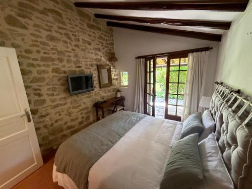 a bedroom with a bed and a tv on the wall at GITE LA FREYDIERE in La Bégude-de-Mazenc