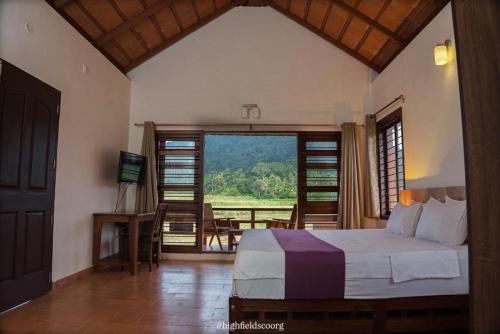 a bedroom with a bed and a window with a view at HighFields Coorg in Virajpet