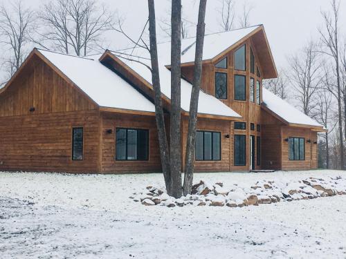 a log home with snow on the ground at Timber Baron Inn in Bayfield