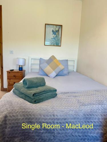 a bedroom with a bed with two towels on it at Feochan Portree in Portree