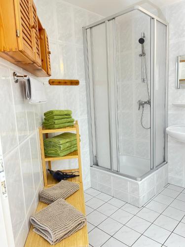 a bathroom with a shower and some towels on a shelf at Finnhaus Fiete in Marlow