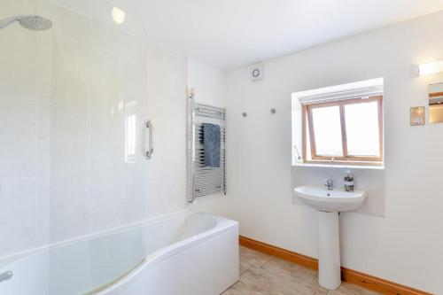 a white bathroom with a tub and a sink at 2 Bed in Holsworthy oc-91755 in Holsworthy