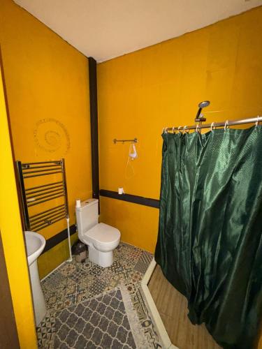 a yellow bathroom with a toilet and a sink at Panorama Gomarduli in Shuakhevi