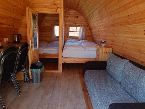 a small room with a bed and a couch in a cabin at 44 Camping Pod "Dieksee" in Silberstedt
