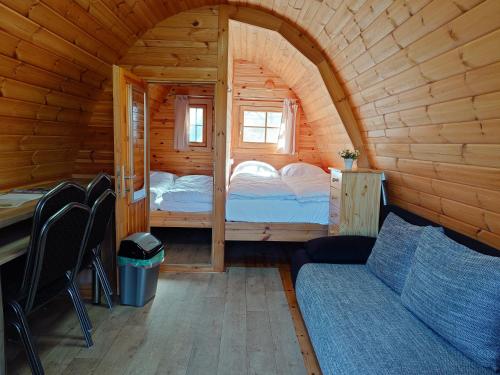 a small room with a bed in a wooden cabin at 47 Camping Pod "Flut" in Silberstedt