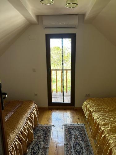 a room with two beds and a large window at Casa ANE in Caransebeş