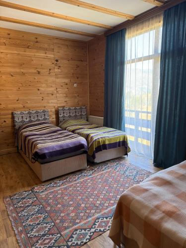 two beds sitting in a room with a window at Panorama Gomarduli in Shuakhevi