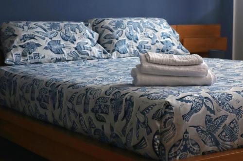 a bed with a blue and white comforter at Casa Nicole Aquileia in Aquiléia