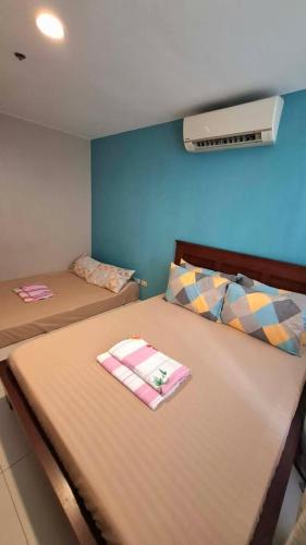 a bedroom with two beds and a air conditioner at Maison Brise Condominium Unit Pico De Loro Nasugbu in Nasugbu