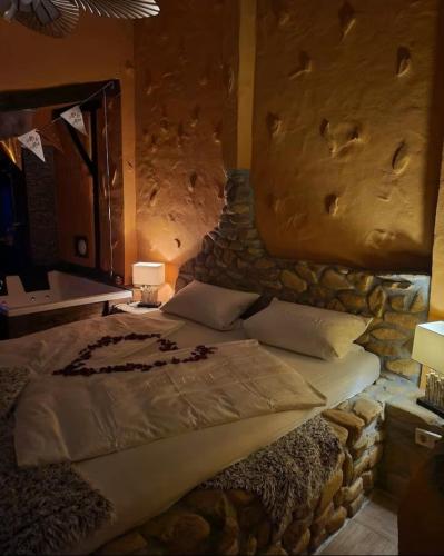 a bedroom with a large bed with a stone wall at Ferienhaus-Sauna Pool Whirlpool in Grimma