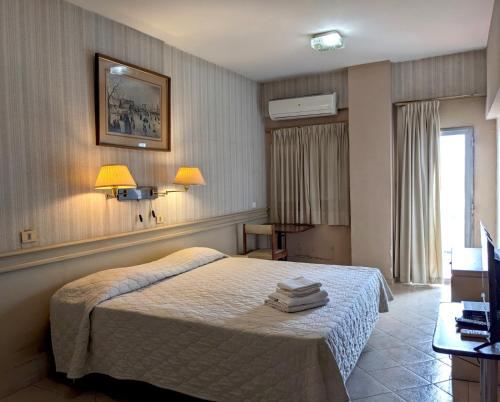 a bedroom with a bed and two lamps on the wall at Hotel Armele Asunción in Asunción